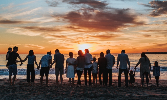 comunità di famiglie che guardano insieme il tramonto